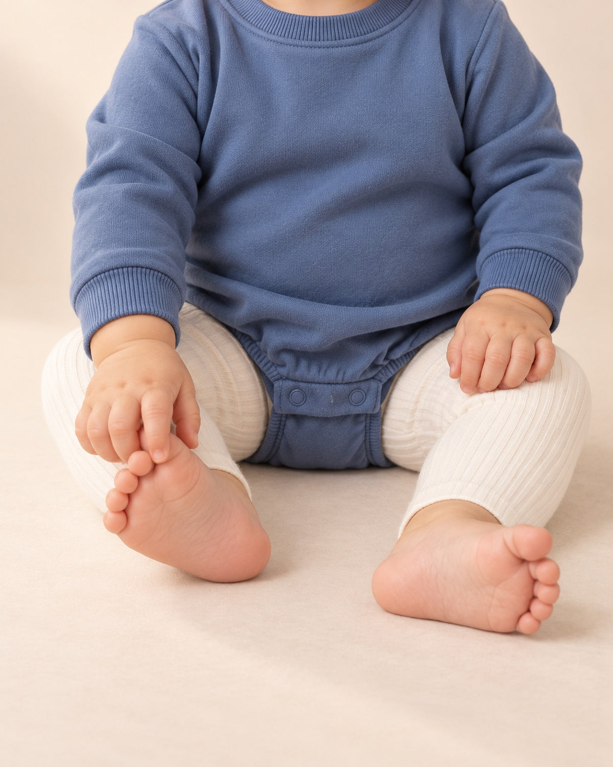 Baby in the Sunny cream ribbed leggings, shown from chest to feet – Cream
