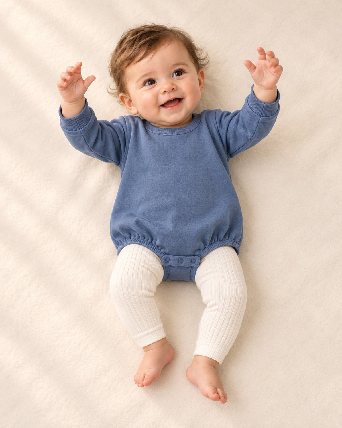 Front view of a baby in cream ribbed leggings with a dusty blue bubble romper – Cream