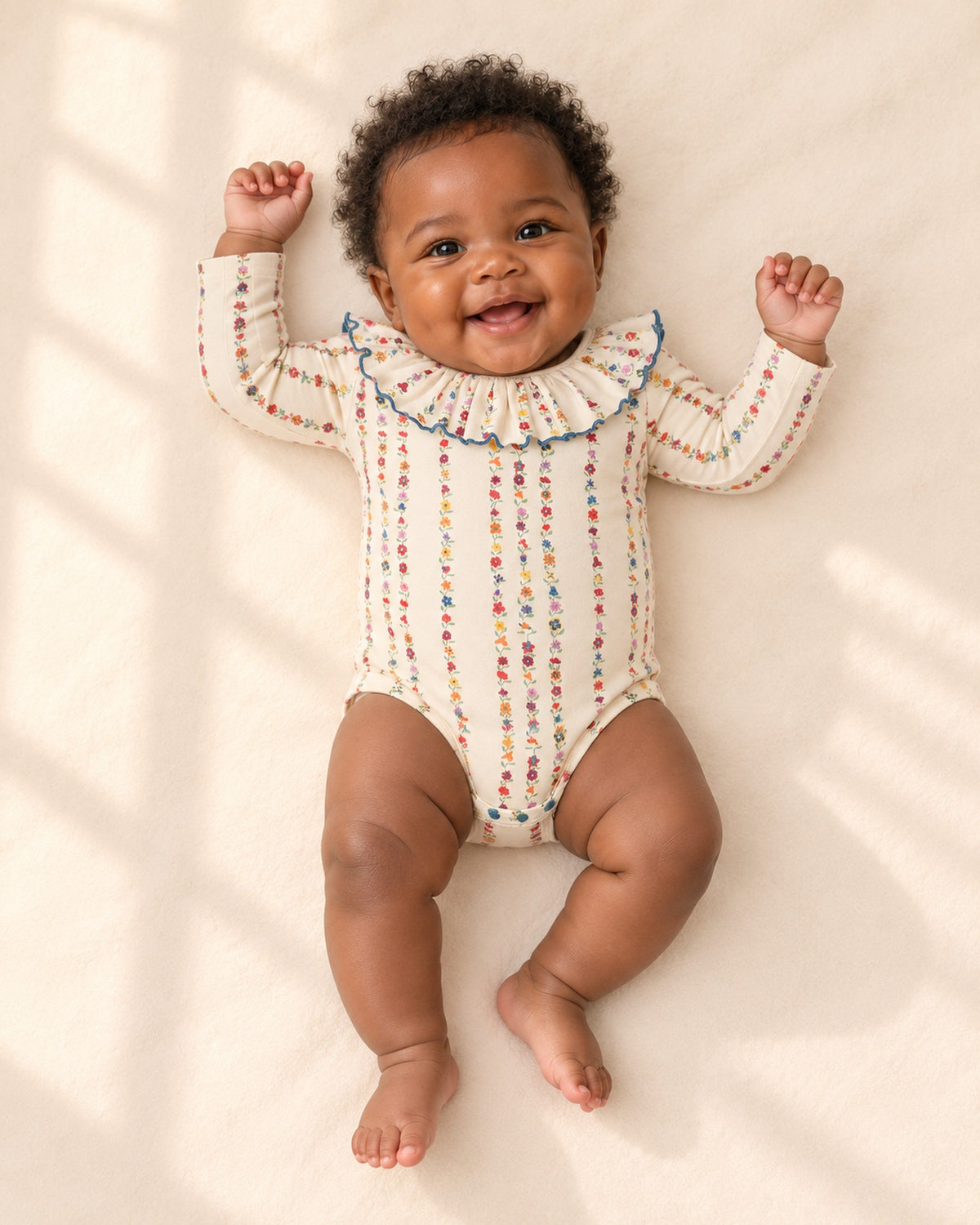 Front view of a baby in the floral ruffle collar bodysuit, full length – Floral Stripe