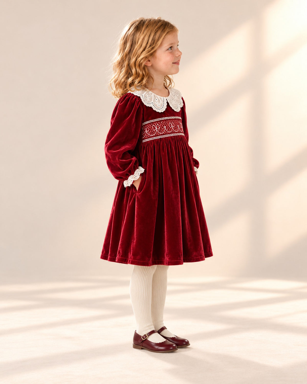 Side view of the red velvet dress showing the full skirt and long sleeves – Red