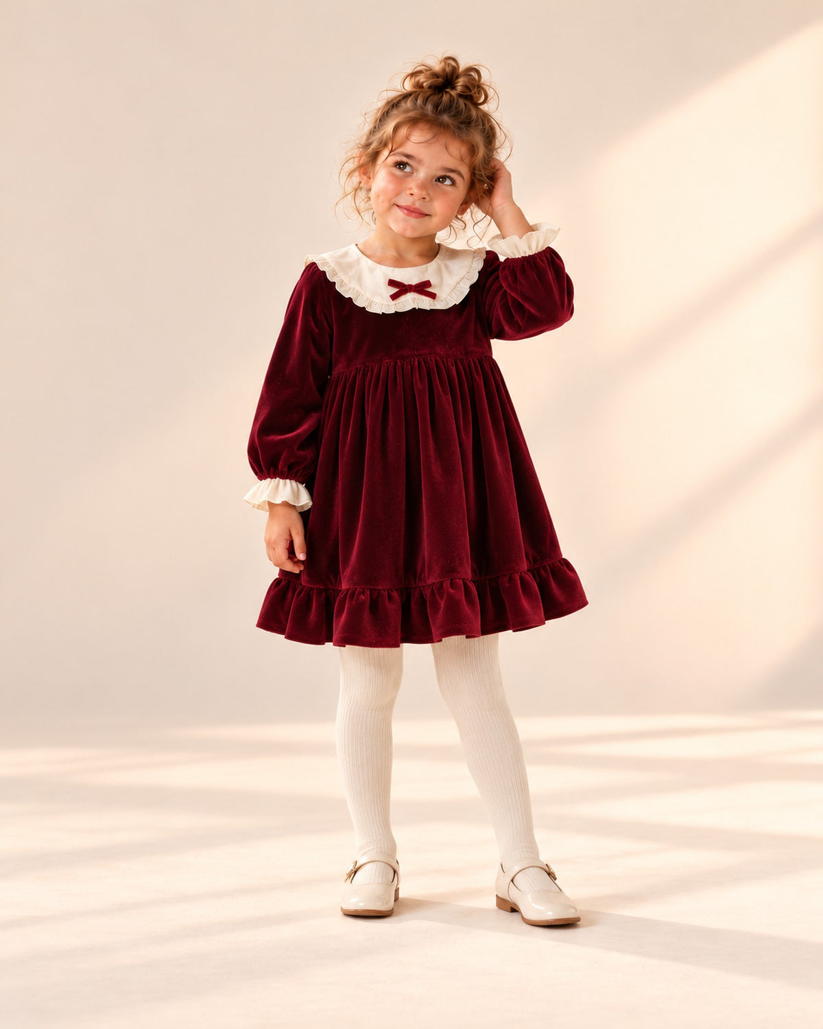 Front view of a girl in the burgundy velvet bow collar dress and cream ribbed tights, full length – Burgundy