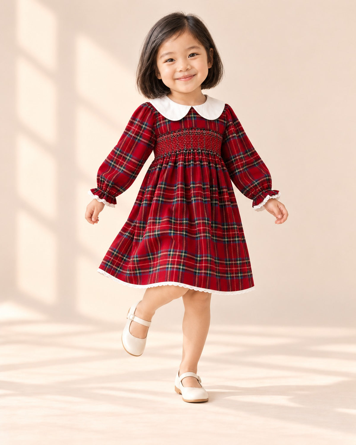 Brother and sister side by side, she in the red tartan smocked dress and he in a holiday tartan shirt with a bow tie and suspenders – Red Tartan