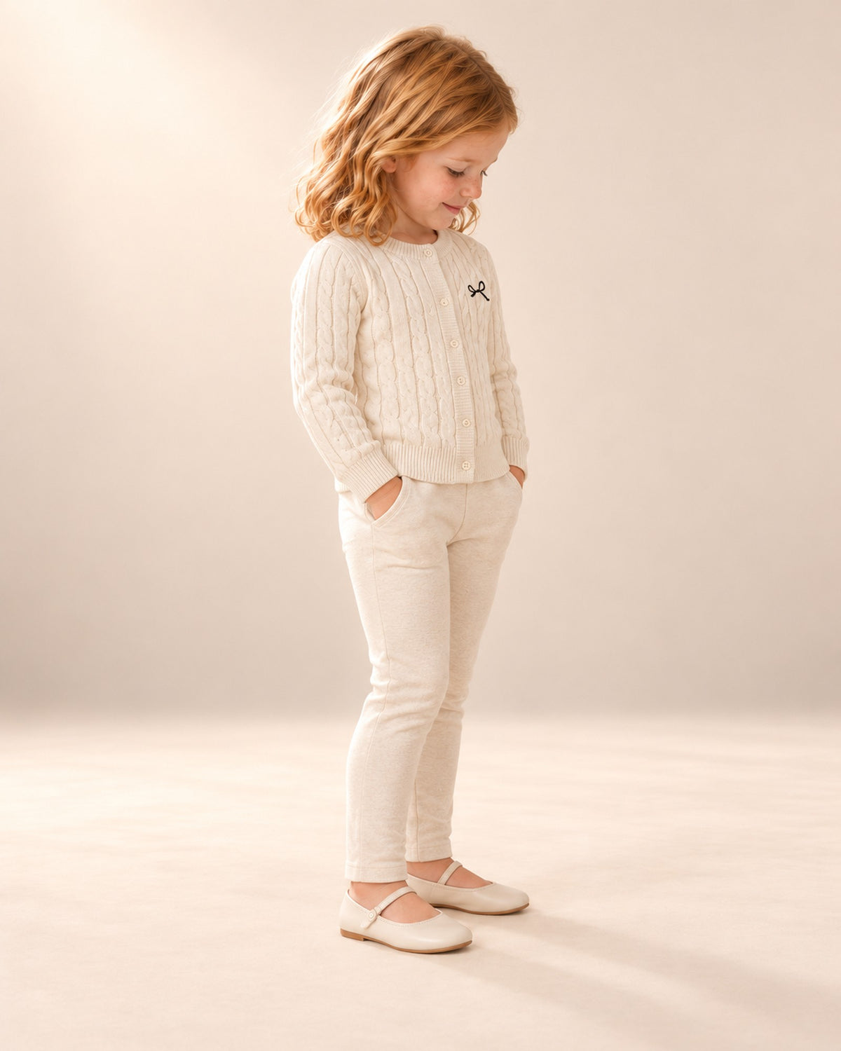 Side view of the cream cable cardigan over the floral dress – Cream