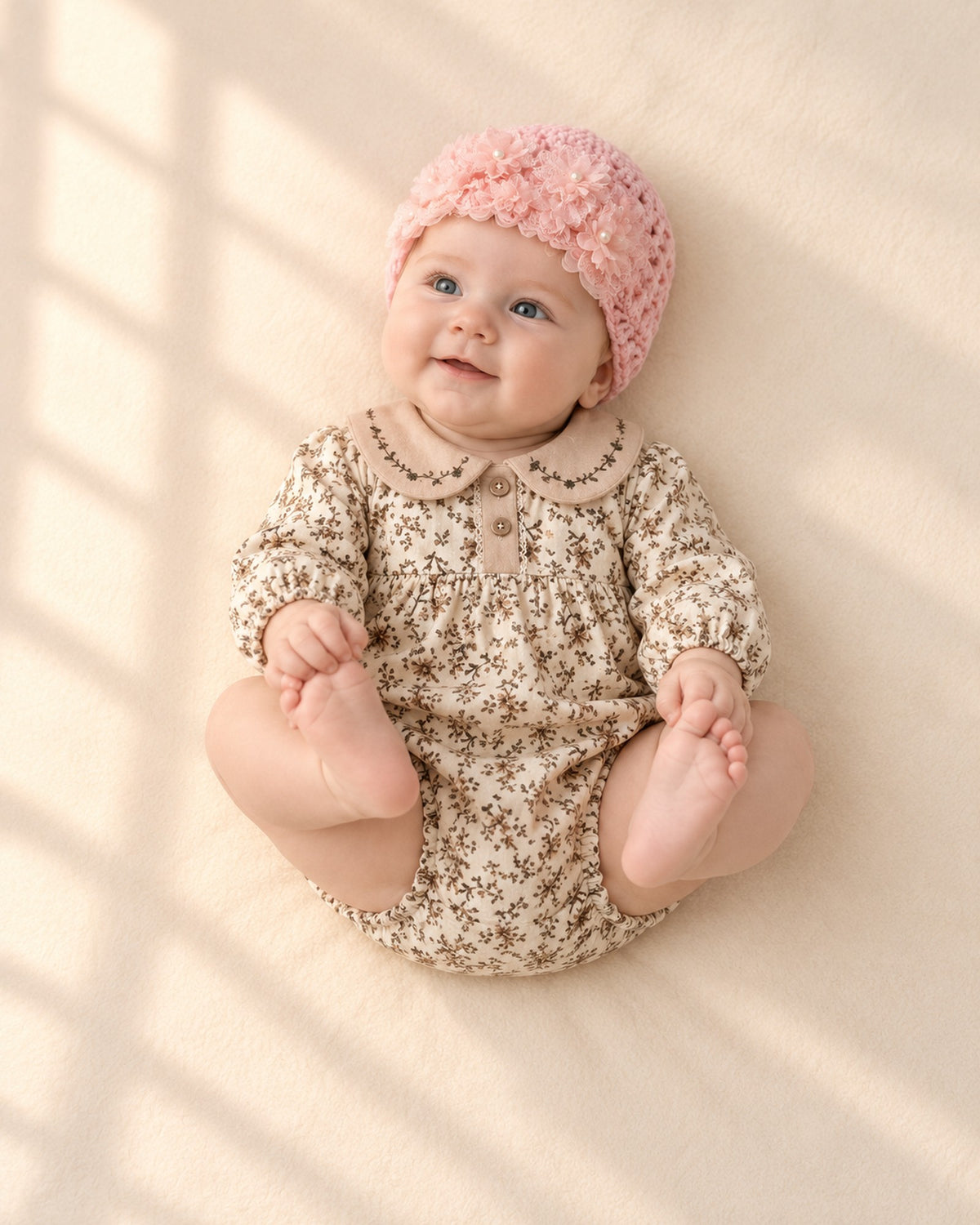 Baby in the pink flower hat and floral bubble romper, shown relaxed – Pink