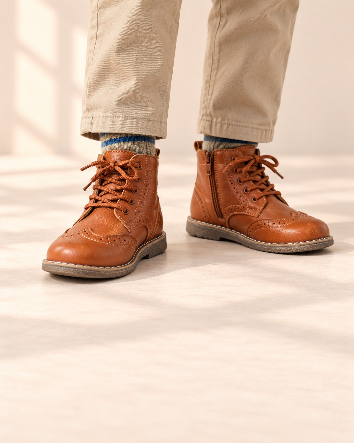 Close-up of a boy's feet in cognac brogue lace-up boots with grey heather socks – Cognac