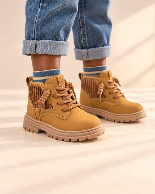 Close-up of a boy's feet in wheat tan lace-up work boots with striped ankle socks – Wheat