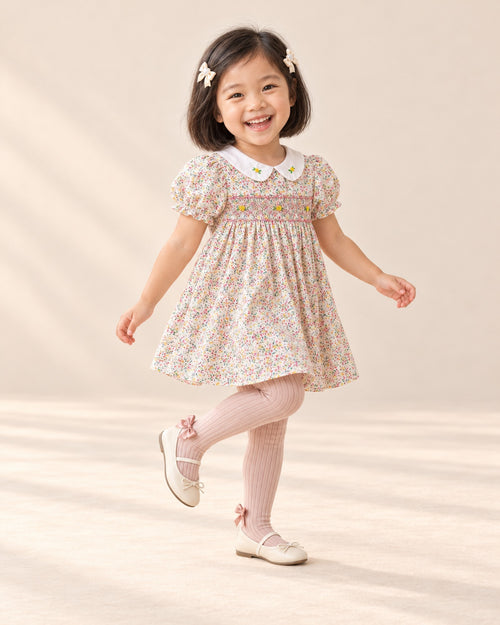 Girl dancing in her floral party dress and blush pink bow tights – Blush Pink