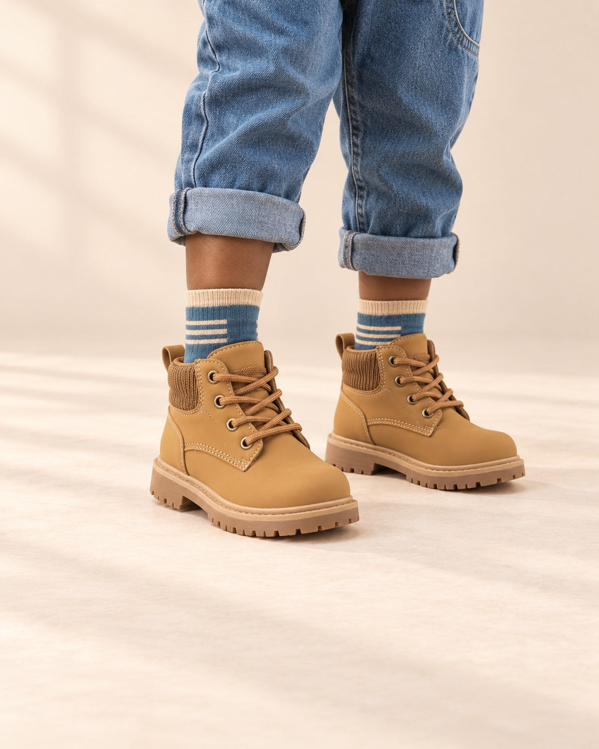 Close-up of a boy's legs from knee to floor in striped ankle socks and wheat work boots – Blue & Beige Mix