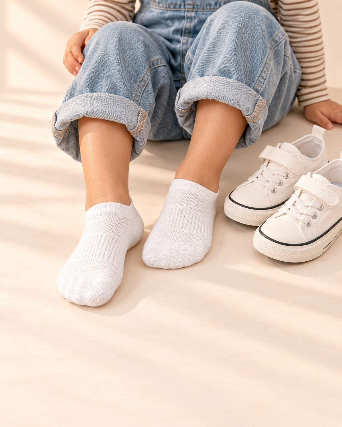 Close-up of a girl's feet in white canvas sneakers with no-show socks – White, Grey & Black