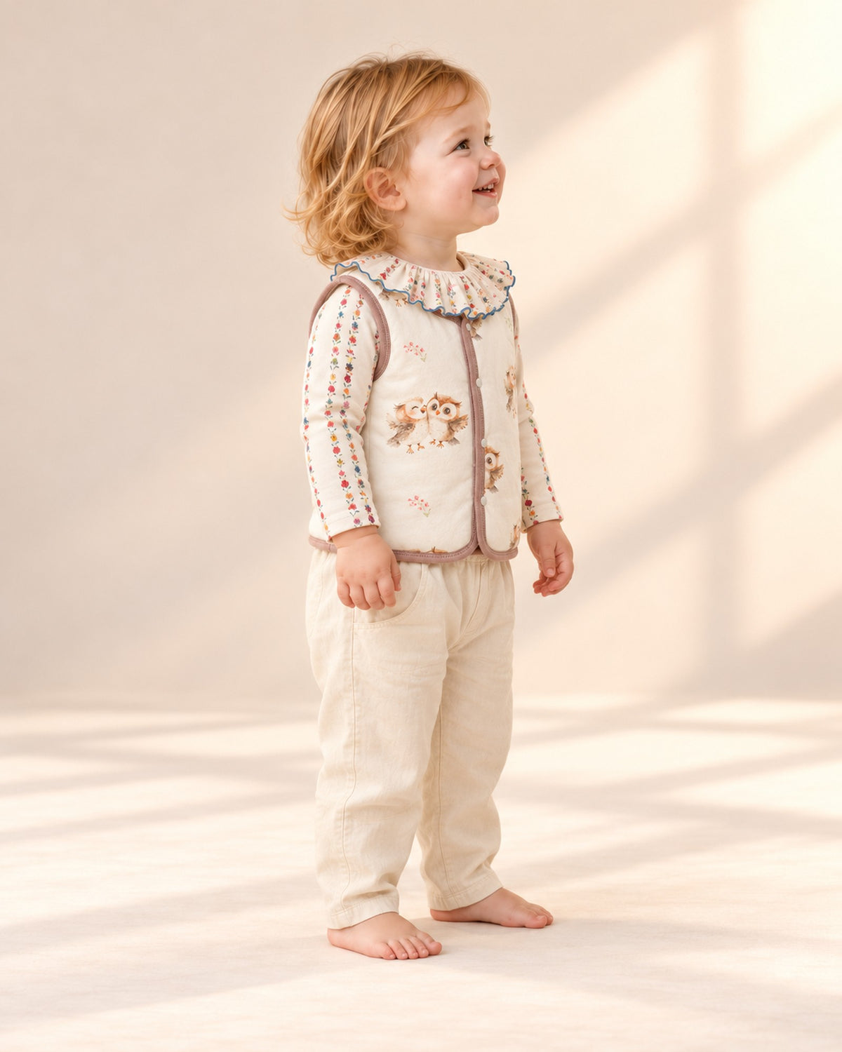 Side view of the cream owl print vest with the ruffle collar bodysuit and cream pants – Cream Owl